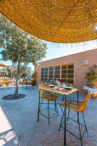 a table and chairs under an umbrella on a patio at Villa Naël Marrakech in Marrakesh