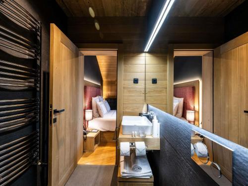 a bathroom with a sink and a bed at Swissôtel Resort Kolasin in Kolašin