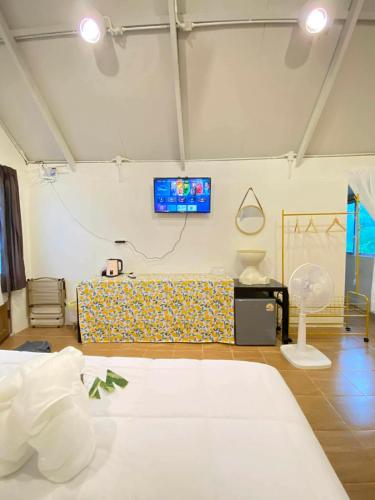 a room with a bed and a tv on the wall at Chamin Longbeach Resort 