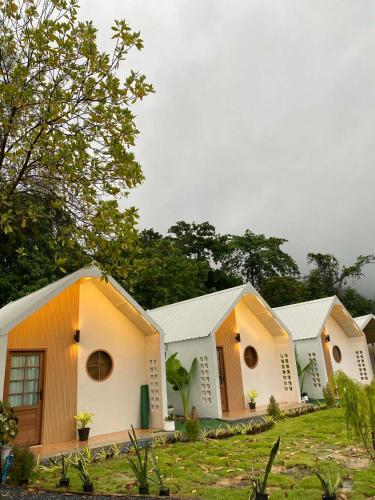 una fila di edifici bianchi con alberi sullo sfondo di Chamin Longbeach Resort 