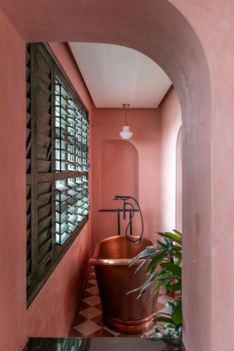 a bathroom with a copper tub and a plant at Abode Jaipur in Jaipur