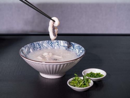 uma tigela de sopa sobre uma mesa com duas tigelas de comida em Grand Mercure Shenzhen Guangming em Shenzhen