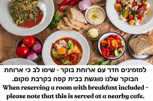 テルアビブにあるIconic Hotelのいくつかの皿に食べ物が載ったテーブル