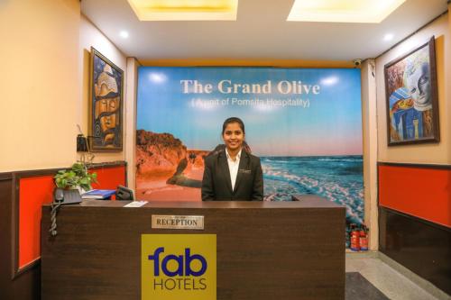 un homme debout derrière un podium à un bureau dans l'établissement FabHotel Grand Olive, à Noida