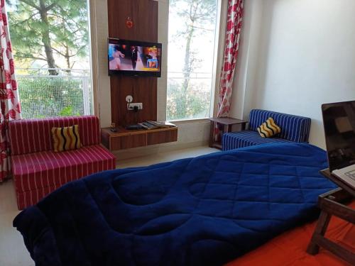 sypialnia z niebieskim łóżkiem i 2 krzesłami w obiekcie Barog BnB hosted by Saurabh Sharma w mieście Barog