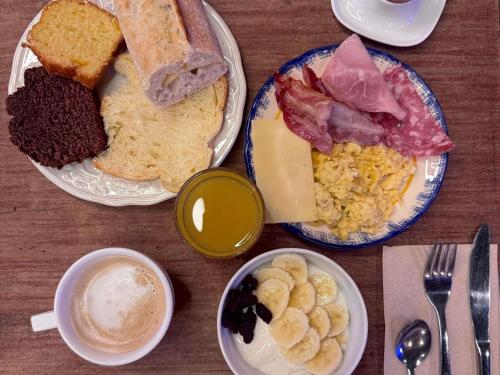 uma mesa com pratos de comida e uma xícara de café em Greet Hotel Brest Aéroport em Guipavas