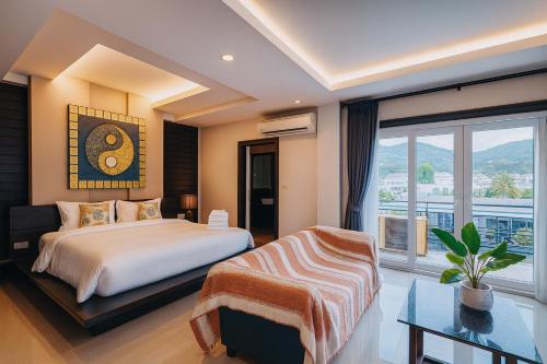 a bedroom with a bed and a large window at Lulu Hotel at The Glasshouse Lion Café in Ban Sire