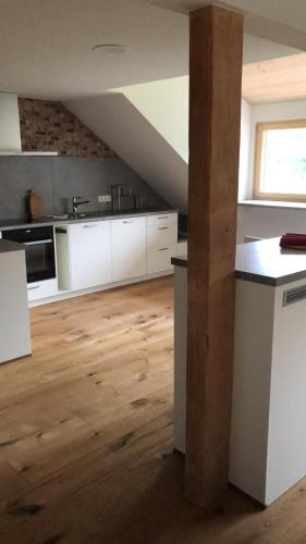 a kitchen with white cabinets and a wooden floor at Daislehof in Münstertal