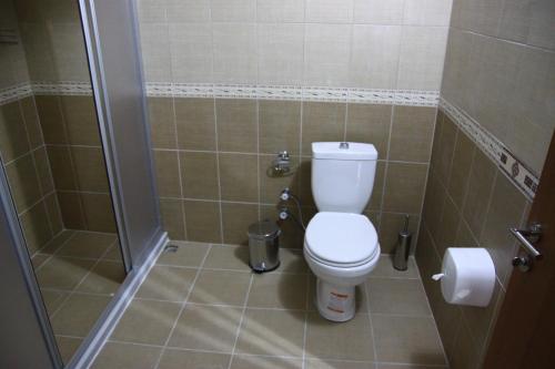 een kleine badkamer met een toilet en een douche bij Deveci Hotel in Mut