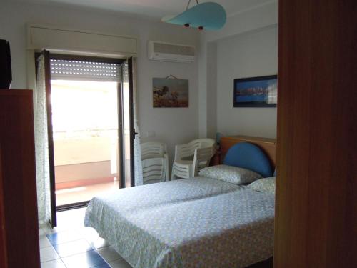 a bedroom with a bed and a window with a patio at Casa Linda Taormina Etna in Fondachello