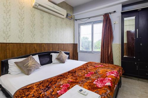 a bedroom with a bed and a window at Pretty Garden View Apartment 3BHK Furnished Flat near Kashi Vishwanath Temple in Varanasi