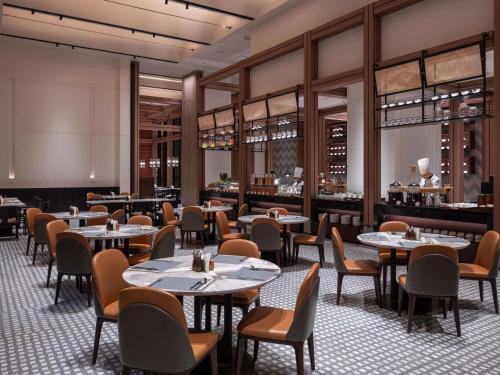 Un restaurante con mesas y sillas y un bar. en Pullman Quanzhou Shuitou, en Quanzhou