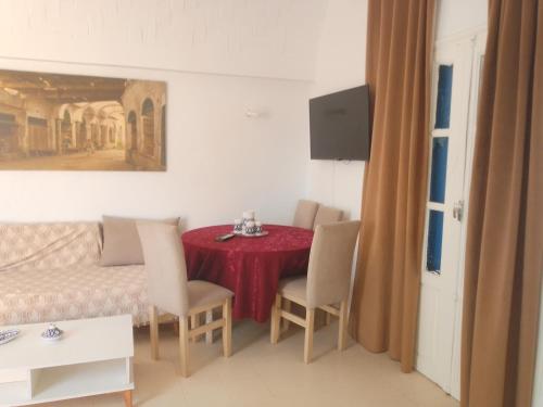 une salle à manger avec une table et des chaises rouges dans l'établissement Taguermess 1, à Djerba