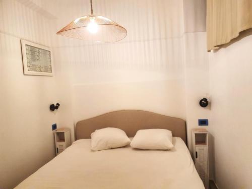 une chambre avec un lit avec deux oreillers dessus dans l'établissement FACE MER TOUT CONFORT situation exceptionnelle, à Antibes