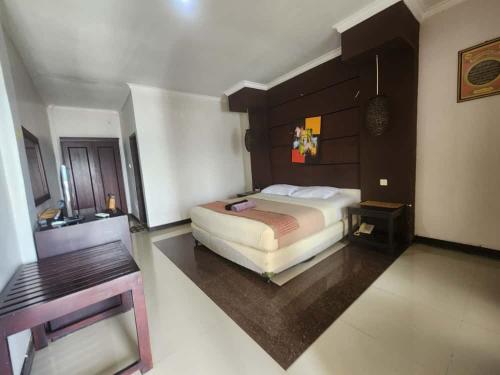 a bedroom with a large bed and a desk at kalaki beach hotel in Daru