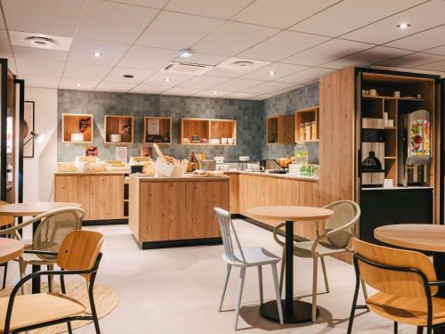 ルーアンにあるibis Rouen Centre Rive Droite Pasteurのテーブルと椅子とカウンターのあるレストラン