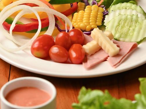 a plate of food with tomatoes and cheese and vegetables at Novotel Living Bangkok Sukhumvit Legacy in Bangkok