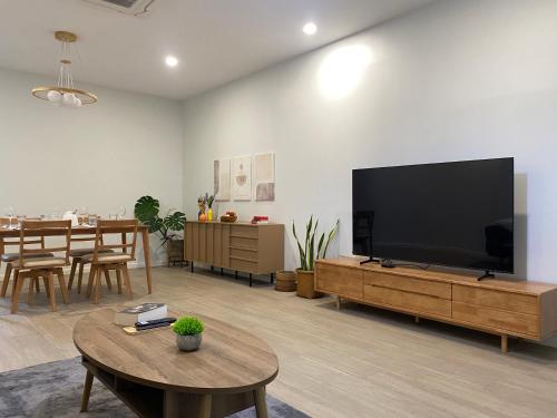 un salon avec une grande télévision à écran plat dans l'établissement Central Nakhon Pathom 2BR Townhouse with AC & Kitchen, à Nakhon Pathom