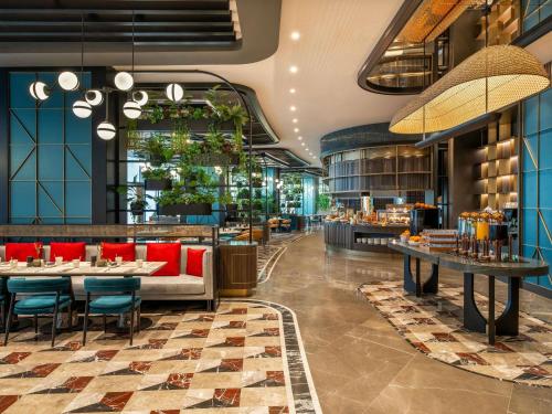 a restaurant with a couch and tables and chairs at Mövenpick Hotel Istanbul Marmara Sea in Istanbul