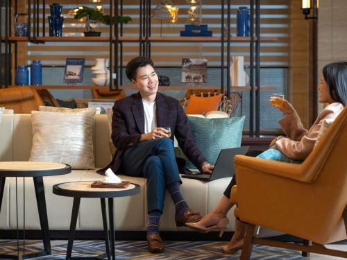 a man and a woman sitting on a couch at Mercure Bangkok Surawong in Bangkok