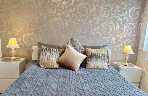 a bedroom with a bed with pillows and two lamps at Wembley Park prime location for Stadium events City break in London