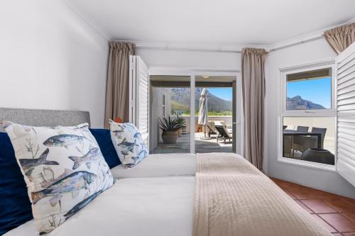 开普敦Pingu Beachhouse with Jacuzzi Hout Bay Cape Town的卧室里有一张床，上面有蓝白色的枕头