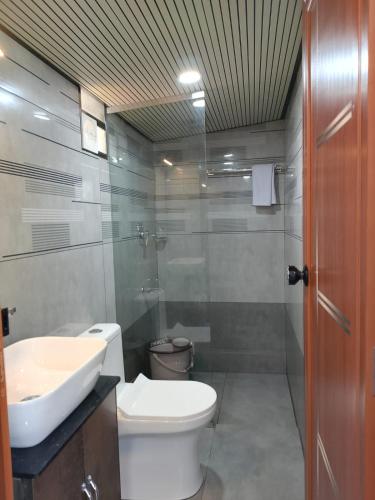 a bathroom with a white toilet and a sink at Casa Resort in Payyannūr