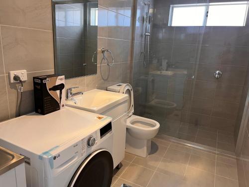 ein Badezimmer mit Waschmaschine und Toilette in der Unterkunft North Parrramatta, NSW 2151 in Sydney