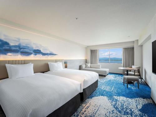 a hotel room with two beds and a large window at Grand Mercure Lake Hamana Resort & Spa in Hamamatsu