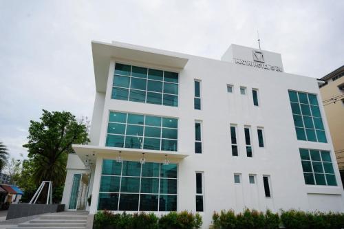 a white building with green windows at Matini Hotel BU