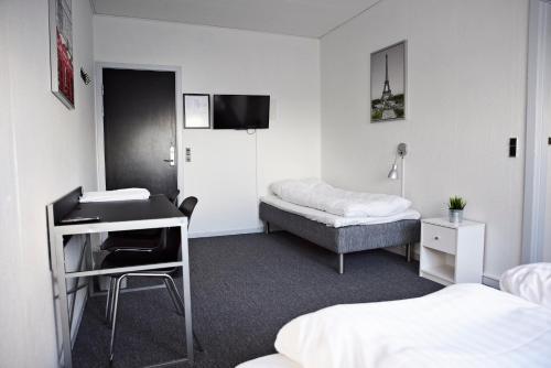 ThyborønにあるDanhostel Thyborønのベッド2台とデスクが備わる客室です。