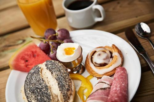 a plate of breakfast food with eggs bread and fruit at Danhostel Thyborøn in Thyborøn