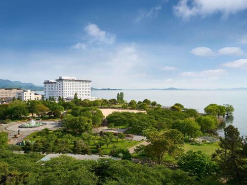 a park in front of a large body of water at Grand Mercure Lake Biwa Resort & Spa in Nagahama