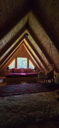 a room with a couch and a swing in a attic at Vikendica GORSKI VUK Jelovica in Berane