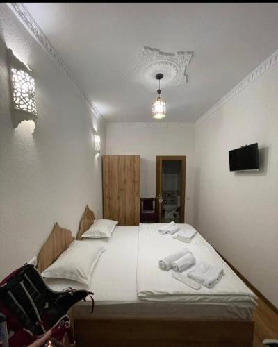a bedroom with a bed with two towels on it at Hotel Naqsh-band Terrace in Bukhara
