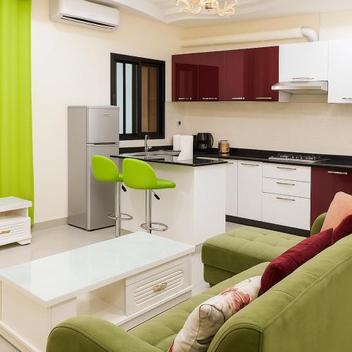 a kitchen with two green chairs and a table at Ste Raphaelle Guest House in Yaoundé