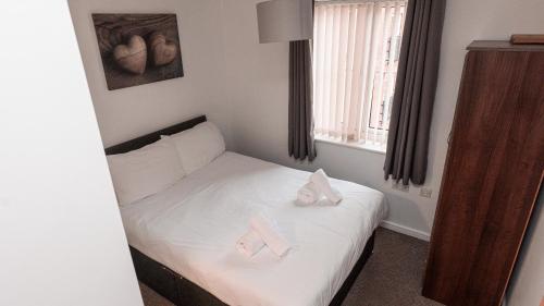une chambre avec un lit avec deux serviettes dessus dans l'établissement Greenings Apt Warrington - 2 Bed with FREE off road Parking & Wifi, à Warrington