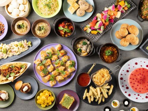 ein Tisch mit Tellern und Schüsseln voller Essen in der Unterkunft Mercure Miyagi Zao Resort & Spa in Zao