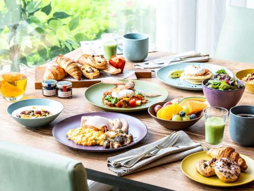a wooden table with plates of food on it at Grand Mercure Yatsugatake Resort & Spa in Hokuto