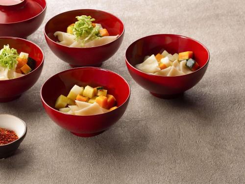 a group of red bowls filled with vegetables on a table at Grand Mercure Yatsugatake Resort & Spa in Hokuto