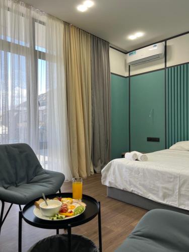 a room with a bed and a tray of food on a table at Prime Hotel Vayk at Lider Complex in Vaykʼ