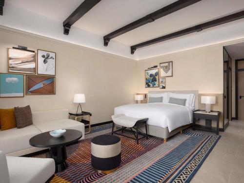 a hotel room with a bed and a couch at Sofitel Al Hamra Beach Resort in Ras al Khaimah