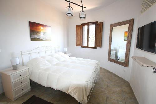 トッレ・スーダにあるFranco's Trullo with Sea Viewの白いベッドルーム(ベッド1台、テレビ付)