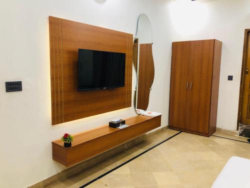 una stanza con una TV a schermo piatto su una parete di Holiday One Hotel & Suites a Karachi