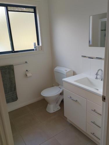 une salle de bain avec toilettes, lavabo et fenêtre dans l'établissement The Cove, à Huon Island