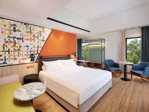 a bedroom with a large white bed and a desk at ibis Styles Serpong BSD City in Tangerang