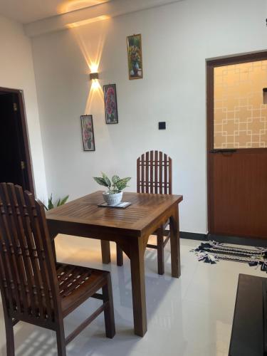 een houten tafel en stoelen in een kamer bij Woori House in Kamburugamuwa