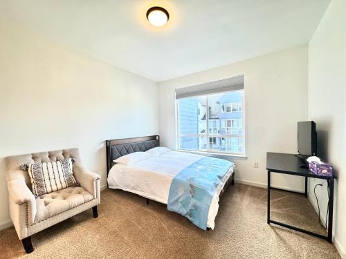a bedroom with a bed and a chair and a window at 2B2B apartment with stunning window -7min to Dome in Tacoma