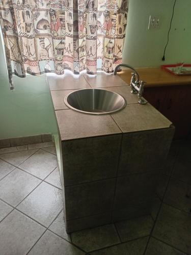 un lavandino in un bagno con una tenda di Brackendene Lodge a Gaborone