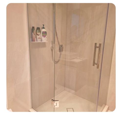 a shower stall with a glass shower door at Bula Suite Flatbush New Zealand - Granny Flat in Auckland